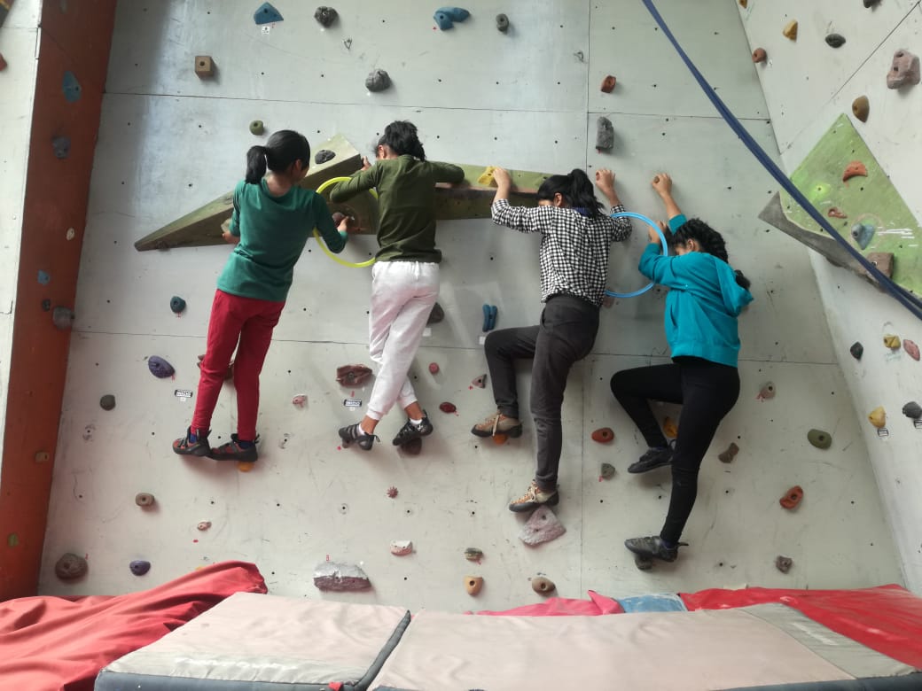 Girls on the climbing wall during an activity day