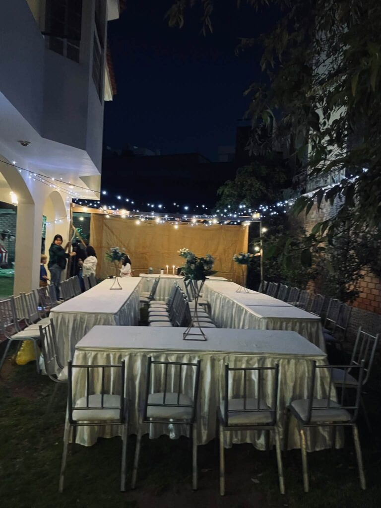 String lights over the sukkah at dusk before guests arrive