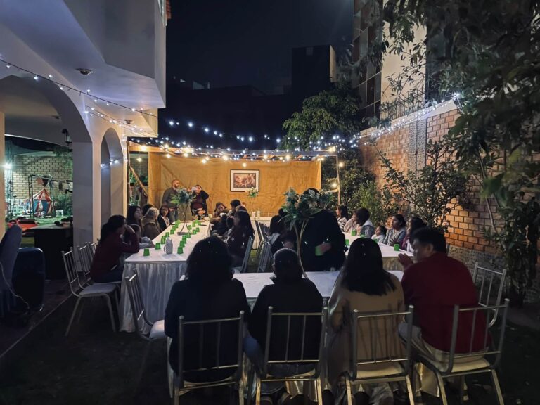 Nearly 50 guests seated at the tables under the sukkah for the Sukkot feast