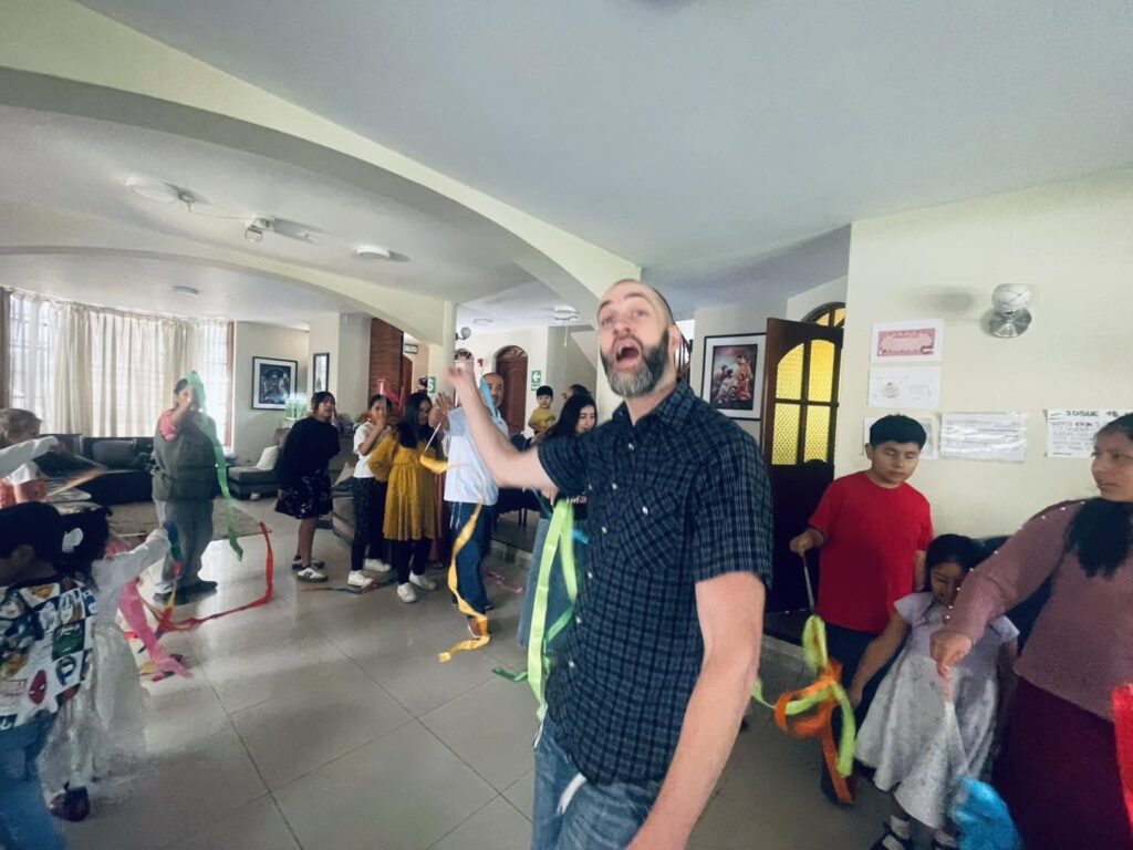Tim Daviscourt leading the ribbon dance through the hall of the home