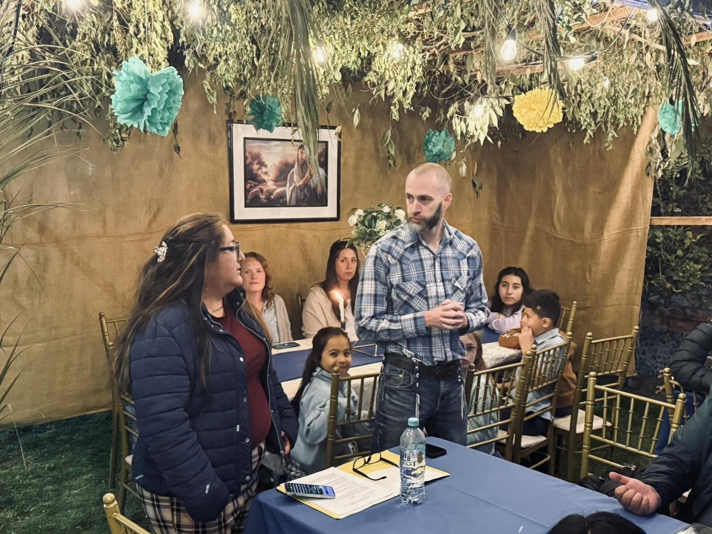 Tim Daviscourt speaking to the families seated under the sukkah before the final feast